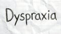 Dyspraxia word written in charcoal on lined paper Royalty Free Stock Photo