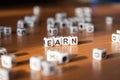 The word EARN made of white plastic blocks on the table.