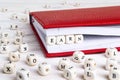 Word Earn written in wooden blocks in red notebook on white wood