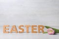 Word EASTER made of wooden letters and spring tulip