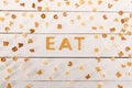 Word eat from breakfast cereal letters and alphabet corn flakes on wooden table Royalty Free Stock Photo