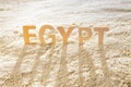 The word Egypt in the sand, long shadows from Egypt