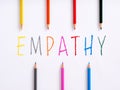 The word empathy and colorful crayons on white background