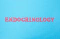 The word endocrinology on a blue background. The concept of the section of medicine dealing with the treatment of diseases of the