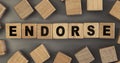 The word ENDORSE on small wooden blocks at the desk. Top view