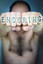 The word ENDURING written on the fists of a man Royalty Free Stock Photo