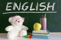 The word `English` written on a blackboard in a language class for early child education. Next, a teddy bear wearing glasses Royalty Free Stock Photo