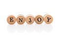 Word Enjoy from circular wooden tiles with letters children toy. Royalty Free Stock Photo