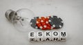 The word Eskom, gambling chips and an electric bulb