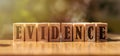 Word EVIDENCE made with building wooden blocks on table in sunlight Royalty Free Stock Photo