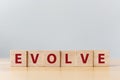 The word EVOLVE on wooden cube block on wood table Royalty Free Stock Photo