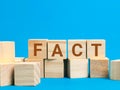 Word fact on wooden cubes against blue background. Royalty Free Stock Photo