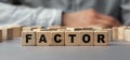 The word FACTOR made from wooden cubes. Selective focus