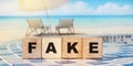 The word FAKE written on wooden cubes. Ocean landscape. Fake news facts concept Royalty Free Stock Photo