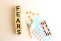 The word FEARS is made of wooden cubes on a white background. Medical concept