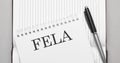 Word fela text on notepad and pen Royalty Free Stock Photo