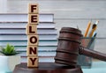 The word FELONY on wooden cubes against the background of the judge's gavel and stand