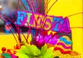 The word `fiesta` written in colorful glitter letters with sombrero and paper flowers