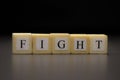 The word FIGHT written on wooden cubes isolated on a black background Royalty Free Stock Photo