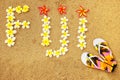 Word Fiji written on a beach with plumeria flowers Royalty Free Stock Photo