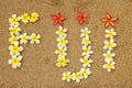 Word Fiji written on a beach with plumeria flowers Royalty Free Stock Photo