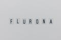 Word FLURONA on gray background. COVID and flu double infection concept