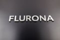 the word flurona laid with silver metal letters on gloss black background