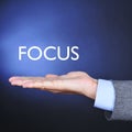 The word focus in the hand of a man