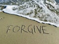 Word forgive in the sand Royalty Free Stock Photo