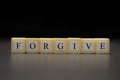 The word FORGIVE written on wooden cubes isolated on a black background Royalty Free Stock Photo