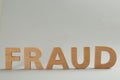 Word Fraud made of wooden letters on grey background, space for text