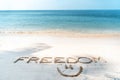 The word freedom written in the sand on a tropical beach, lifestyle vacation and travel design concept Royalty Free Stock Photo