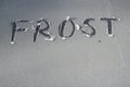 The word frost written in the icy frost on a window.