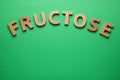 Word Fructose made of wooden letters on green background, flat lay. Space for text Royalty Free Stock Photo