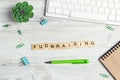 Word Fundraising written in wooden blocks in red notebook on white wooden table