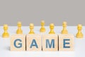 The word game is on wooden cubes among chess pieces of pawns. The concept of team play Royalty Free Stock Photo