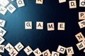 Word GAME with wooden letters on black Board with dice and letter in the circle Royalty Free Stock Photo