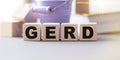 Word GERD Gastroesophageal reflux disease on wooden cubes on the table in isolation Royalty Free Stock Photo