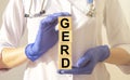 Word gerd on wooden cubes in doctor hands close up