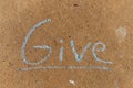 The word Give written with sidewalk chalk on gray concrete pavement background