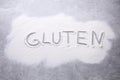 Word Gluten written with flour on grey background, top view Royalty Free Stock Photo