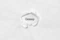 Word gossip on white isolated background through the wound hole in the paper.