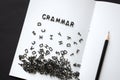 The word grammar is made from black english letters scattered on a clean white blank sheet, learning english