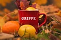 Word grippe written on red mug. Selective focus and noise