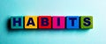 The word HABITS is written on multicolored bright wooden cubes on a light blue background Royalty Free Stock Photo