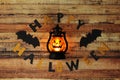 Word Halloween made of black and yellow letters on wood table with jack of lantern. Congratulations to loved ones, family, friends Royalty Free Stock Photo