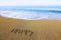Word HAPPY written on beach sand a
