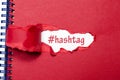 The word hashtag appearing behind torn paper