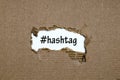 The word hashtag appearing behind torn paper