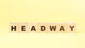Word headway made with small wooden blocks on yellow Royalty Free Stock Photo